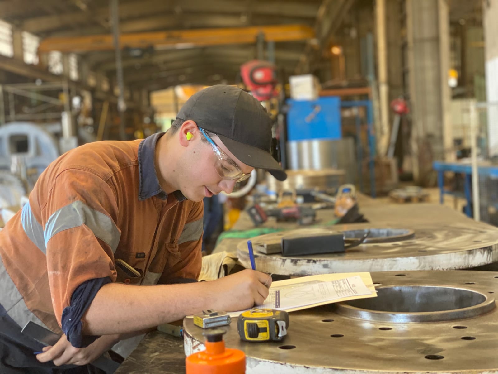 ABC tradesman performing a quality-assurance measurement on a large machined circular flange in the Paget workshop