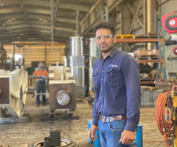 An ABC Heavy Engineering team member standing on the workshop floor amongst machinery