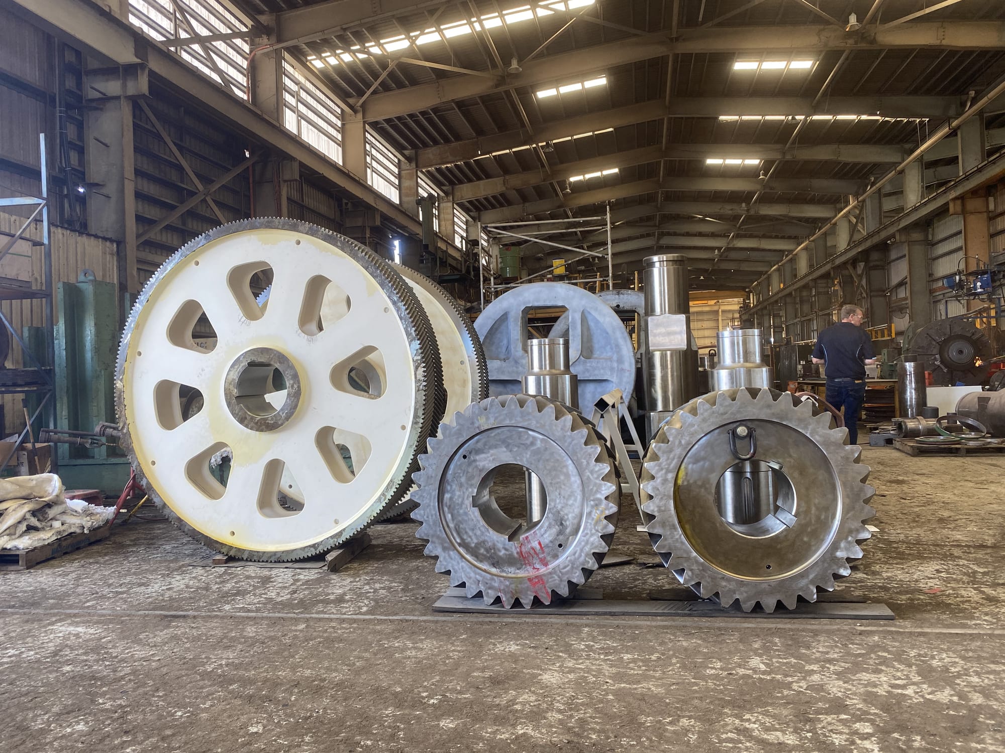 ABC machine shop floor with a large bull gear, stacked helical gears, pinions and machined shafts